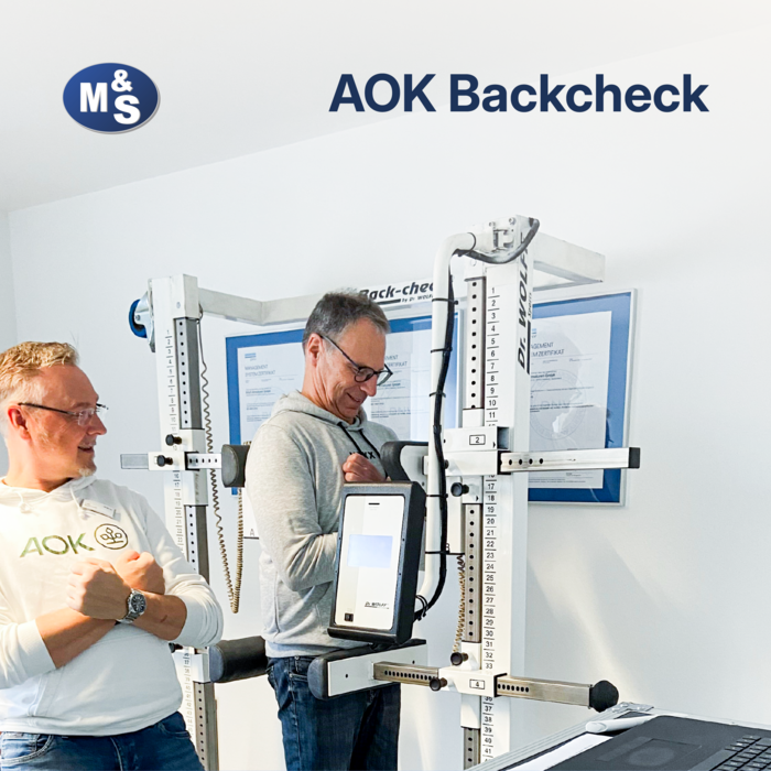 AOK-Backcheck at M&S A manager from AOK-Gesundheit performing a back check on an employee at M&S using a measuring device.